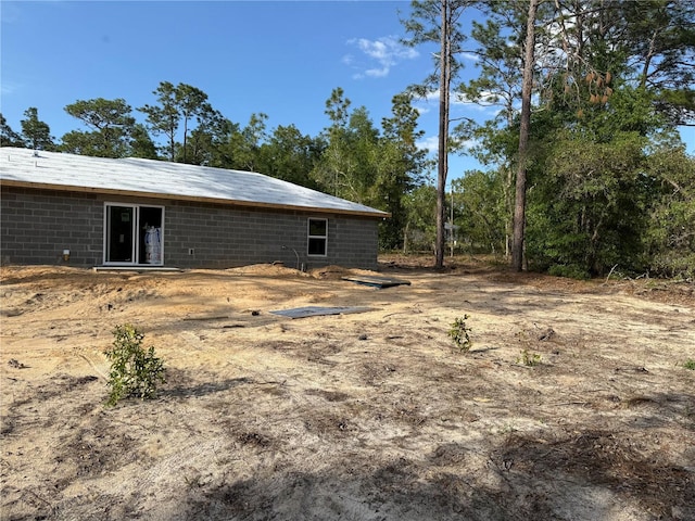 rear view of property featuring concrete block siding