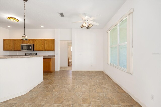 9649 SW 90th St, Ocala, FL 34481 - kitchen featuring stainless steel microwave, a ceiling fan, stone finish floors, light countertops, and recessed lighting