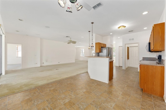 9649 SW 90th St, Ocala, FL 34481 - kitchen with a ceiling fan, light carpet, brown cabinets, appliances with stainless steel finishes, and plenty of natural light