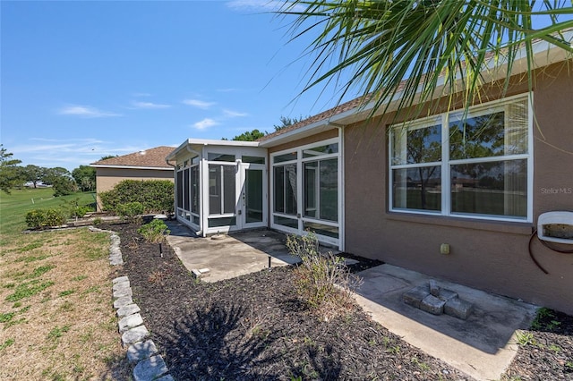 9649 SW 90th St, Ocala, FL 34481 - rear view of house featuring a sunroom, stucco siding, and a patio area