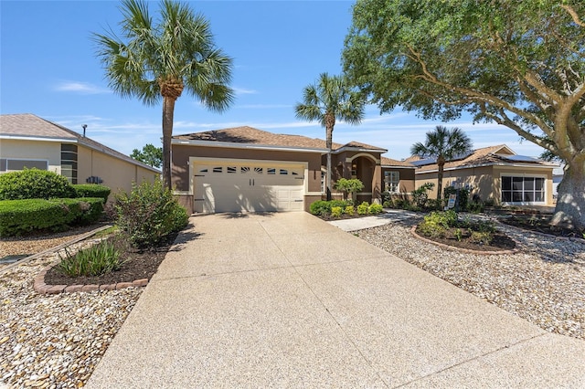 9649 SW 90th St, Ocala, FL 34481 - view of front facade with an attached garage, driveway, stucco siding, and roof mounted solar panels