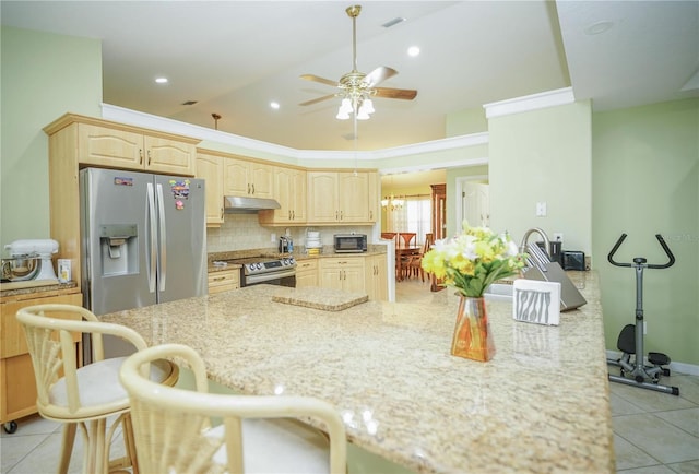 7475 SE 105th Pl, Belleview, FL 34420 - kitchen featuring appliances with stainless steel finishes, under cabinet range hood, ceiling fan, light stone counters, and a kitchen bar