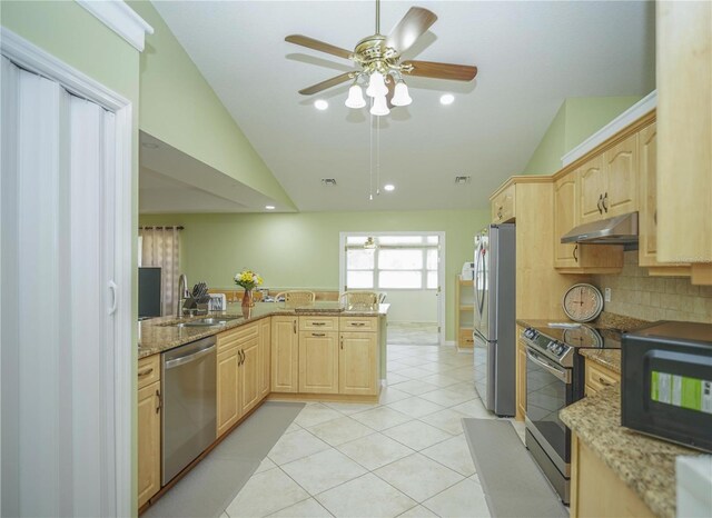 7475 SE 105th Pl, Belleview, FL 34420 - kitchen with stainless steel appliances, light brown cabinets, vaulted ceiling, a sink, and under cabinet range hood