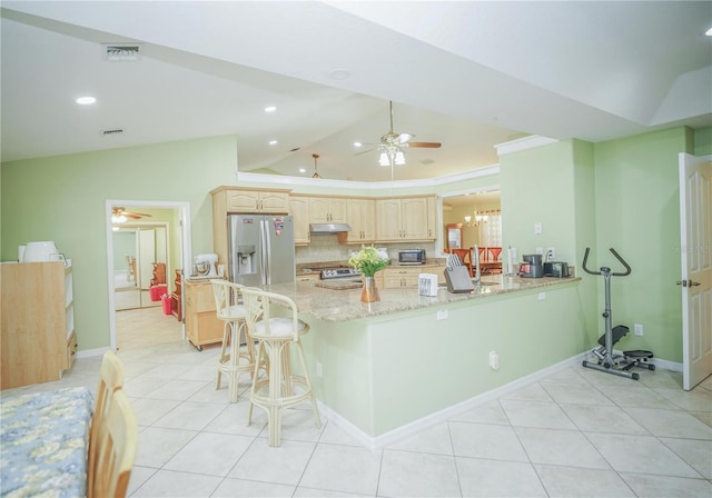 7475 SE 105th Pl, Belleview, FL 34420 - kitchen with stainless steel appliances, a ceiling fan, light brown cabinets, under cabinet range hood, and light stone countertops