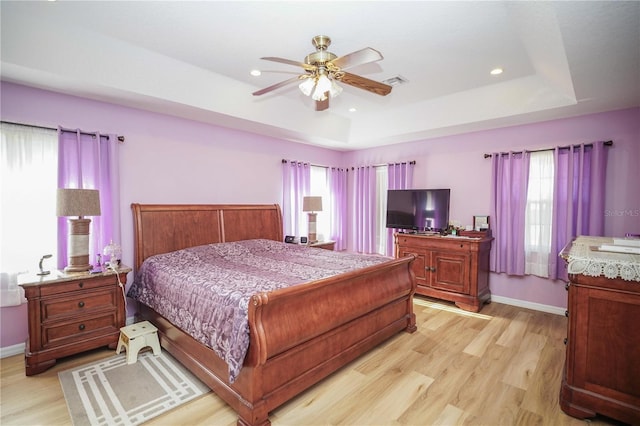 7475 SE 105th Pl, Belleview, FL 34420 - bedroom featuring multiple windows, light wood-type flooring, a tray ceiling, and recessed lighting