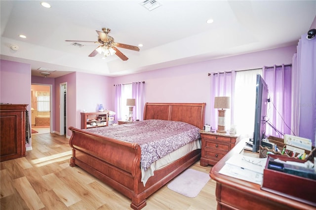 7475 SE 105th Pl, Belleview, FL 34420 - bedroom featuring light wood-type flooring, a raised ceiling, recessed lighting, ceiling fan, and connected bathroom