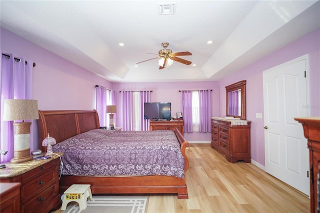 7475 SE 105th Pl, Belleview, FL 34420 - bedroom with multiple windows, a raised ceiling, light wood-style floors, recessed lighting, and a ceiling fan