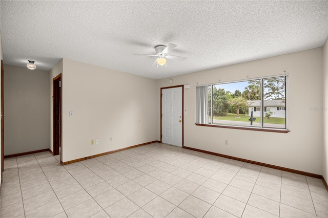 empty room featuring ceiling fan, a textured ceiling, and baseboards