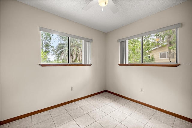 empty room with ceiling fan, baseboards, and a textured ceiling