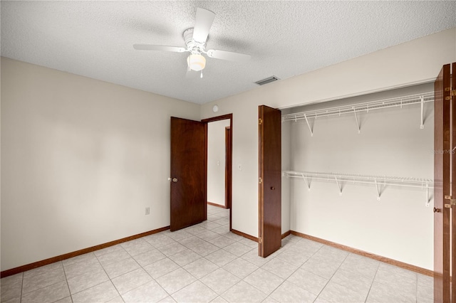unfurnished bedroom with a textured ceiling, a closet, a ceiling fan, and baseboards