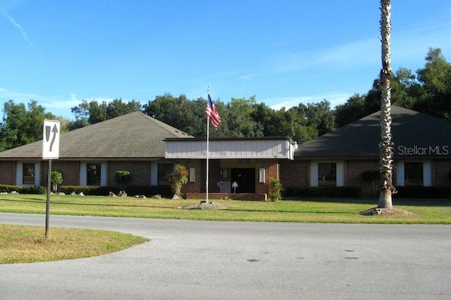 single story home featuring a front lawn and brick siding