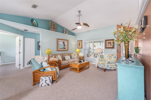 carpeted living room with ceiling fan and vaulted ceiling