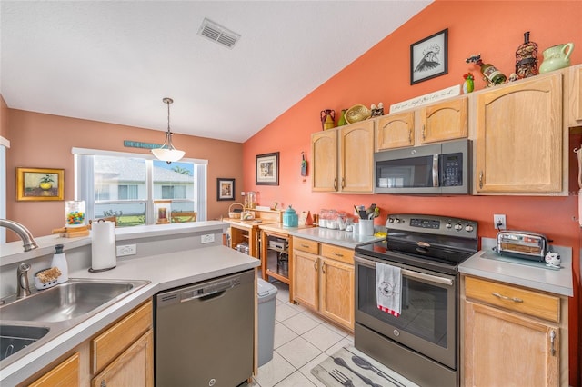 kitchen featuring stainless steel appliances, a sink, lofted ceiling, light brown cabinets, and light countertops