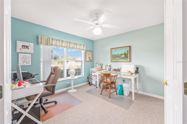 carpeted home office with a ceiling fan and baseboards