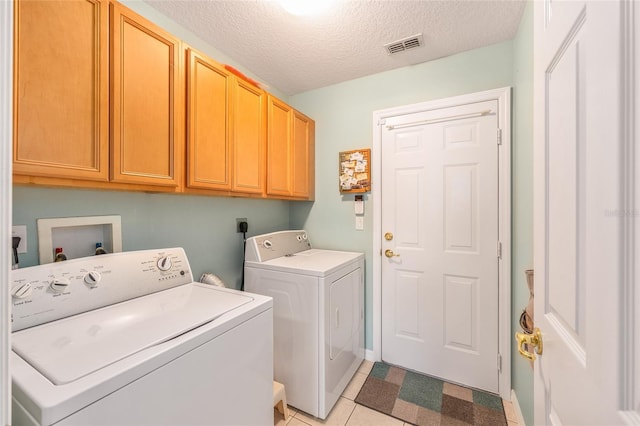 clothes washing area with cabinet space, independent washer and dryer, and a textured ceiling