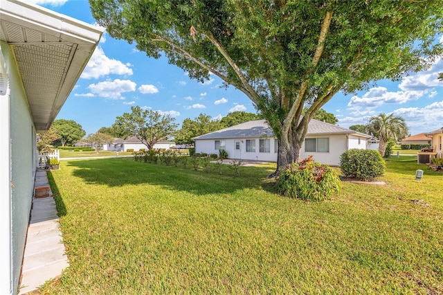 view of grassy yard with central AC