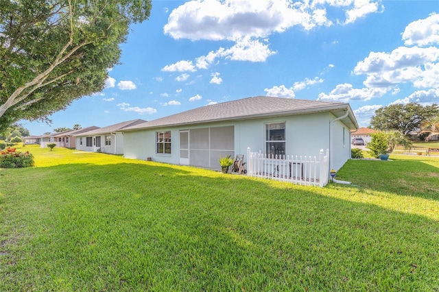 back of house with a lawn and stucco siding