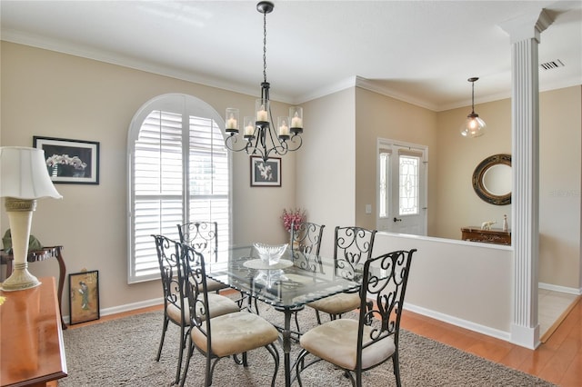 2550 NW 55th Avenue Rd, Ocala, FL 34482 - dining room featuring wood finished floors, crown molding, a chandelier, baseboards, and ornate columns