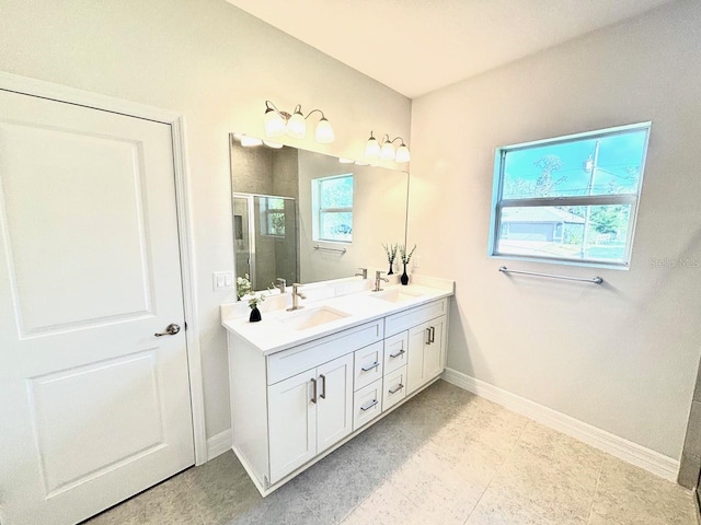 full bathroom featuring baseboards, a shower stall, plenty of natural light, and double vanity