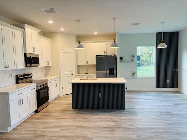 kitchen with stainless steel appliances, light wood-type flooring, light countertops, white cabinets, and a sink
