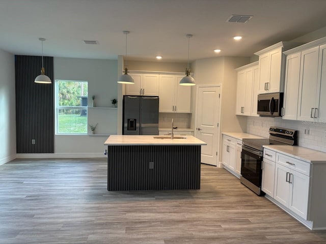 kitchen with stainless steel appliances, white cabinetry, light countertops, and recessed lighting