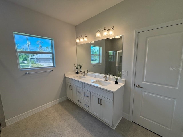 bathroom featuring baseboards, double vanity, and a shower with door