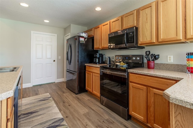 1690 SW 158th Ln, Ocala, FL 34473 - kitchen featuring stainless steel appliances, light countertops, light wood finished floors, recessed lighting, and a textured ceiling