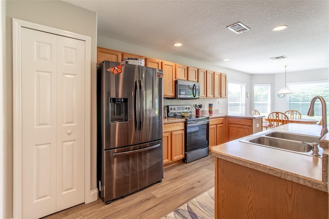 1690 SW 158th Ln, Ocala, FL 34473 - kitchen featuring appliances with stainless steel finishes, a sink, a textured ceiling, light wood-style floors, and recessed lighting