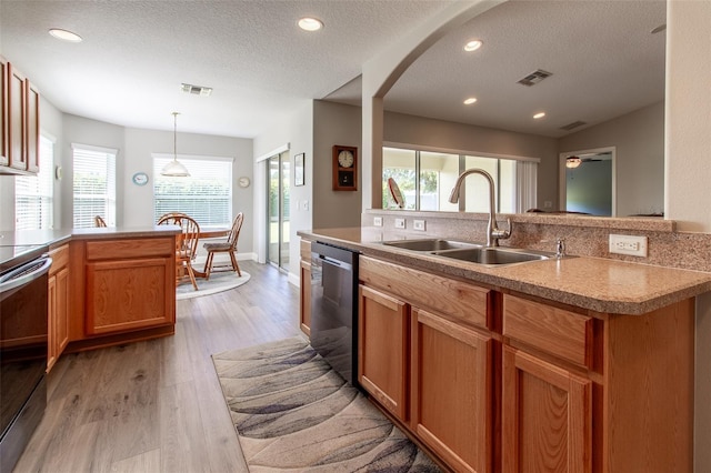 1690 SW 158th Ln, Ocala, FL 34473 - kitchen with a sink, stainless steel dishwasher, plenty of natural light, a textured ceiling, and light wood-type flooring