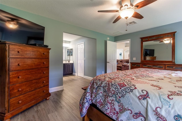 1690 SW 158th Ln, Ocala, FL 34473 - bedroom with wood finished floors, ensuite bathroom, baseboards, and a ceiling fan
