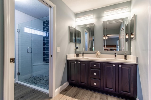 1690 SW 158th Ln, Ocala, FL 34473 - full bath with wood finished floors, a stall shower, baseboards, and double vanity