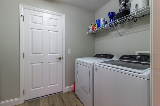 1690 SW 158th Ln, Ocala, FL 34473 - laundry area with washer and clothes dryer, light wood-style floors, and baseboards