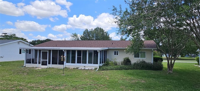 rear view of house featuring a sunroom and a yard