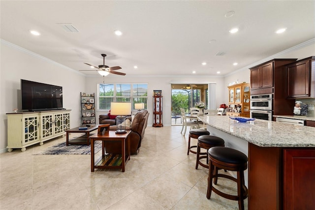 living room with ornamental molding, ceiling fan, recessed lighting, light tile patterned flooring, and baseboards
