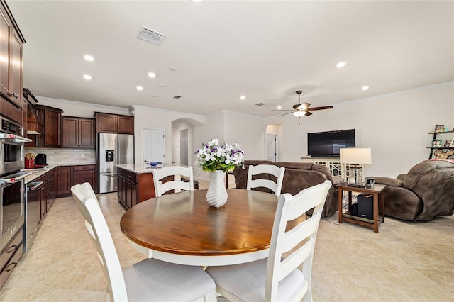 dining room with ornamental molding, arched walkways, ceiling fan, recessed lighting, and light tile patterned floors