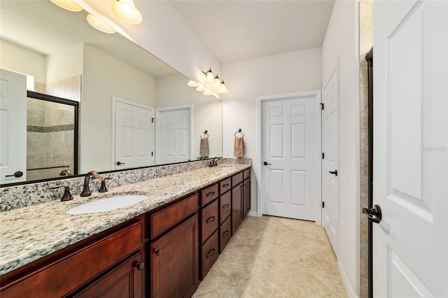 bathroom featuring a shower stall, double vanity, and tile patterned flooring