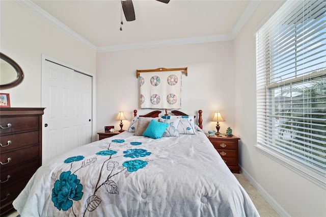 carpeted bedroom featuring multiple windows, crown molding, baseboards, a closet, and a ceiling fan