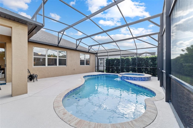 view of pool featuring a patio area, a pool with connected hot tub, and glass enclosure