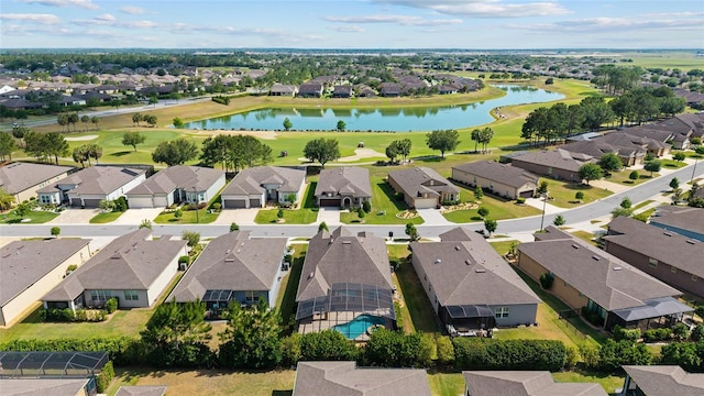 aerial perspective of suburban area featuring a nearby body of water and a golf course
