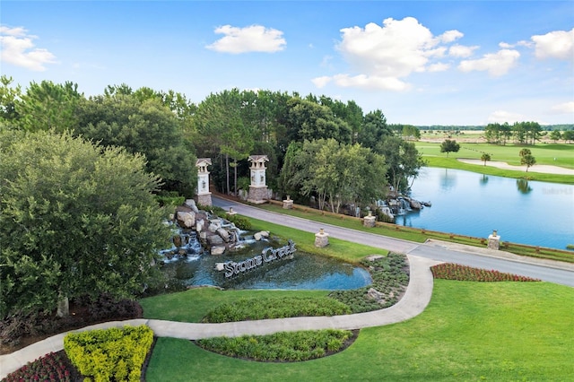 view of property's community featuring a lawn and a water view