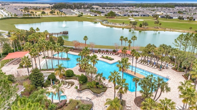 aerial view of residential area with a pool area and a nearby body of water