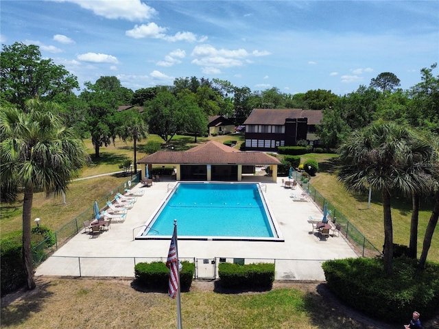 community pool featuring a patio area and view of wooded area