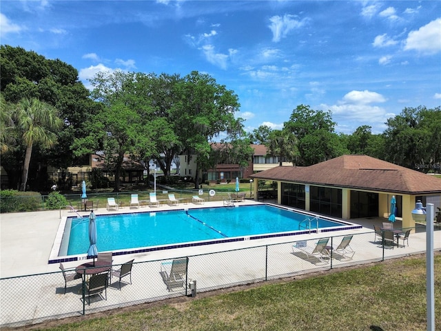 community pool with fence and a patio area