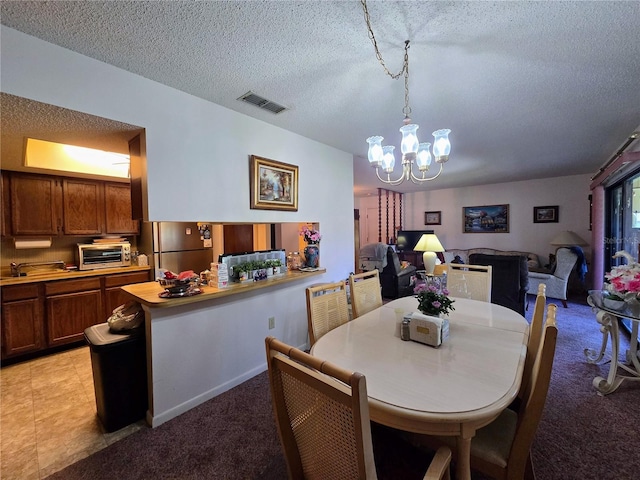 dining area with a chandelier, a textured ceiling, and light carpet