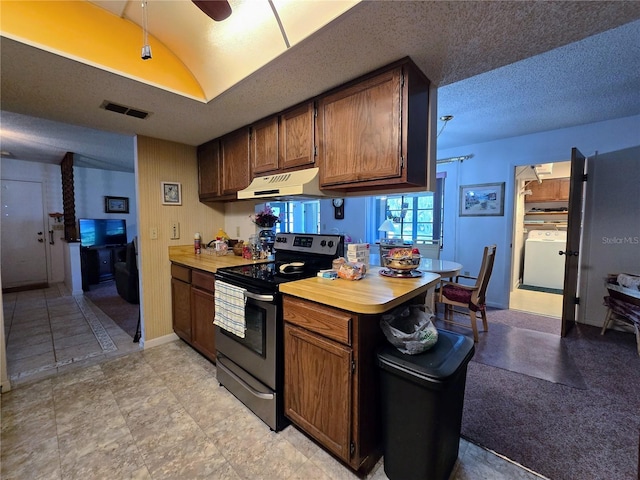 kitchen featuring stainless steel range with electric cooktop, under cabinet range hood, washer / clothes dryer, light countertops, and a ceiling fan