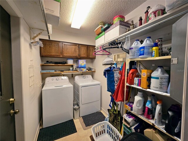 washroom featuring washer and dryer, baseboards, a textured ceiling, cabinet space, and tile patterned floors
