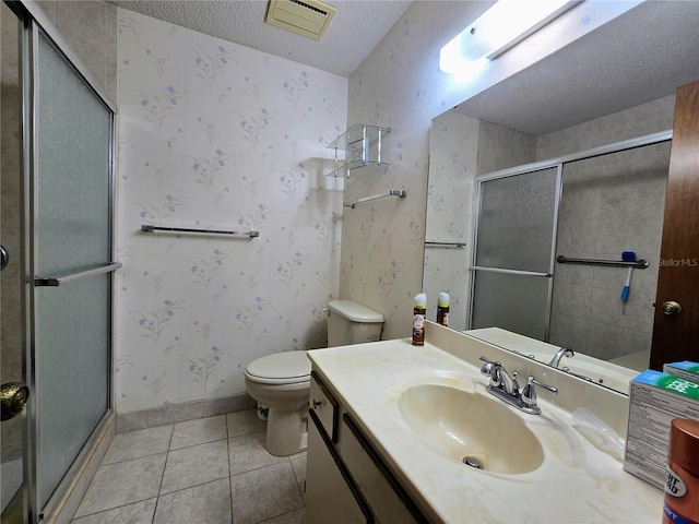 bathroom featuring a textured ceiling, a stall shower, toilet, tile patterned flooring, and vanity