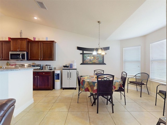 9677 SW 56th Cir, Ocala, FL 34476 - kitchen featuring vaulted ceiling, stainless steel microwave, light countertops, light tile patterned floors, and a chandelier