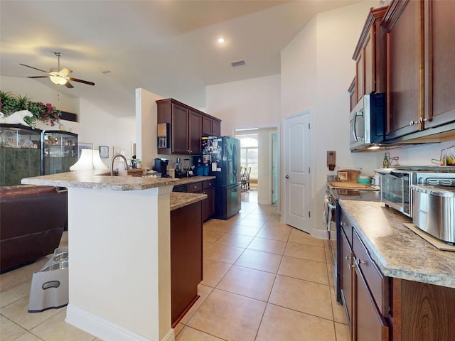 9677 SW 56th Cir, Ocala, FL 34476 - kitchen featuring appliances with stainless steel finishes, a peninsula, open floor plan, ceiling fan, and light tile patterned floors