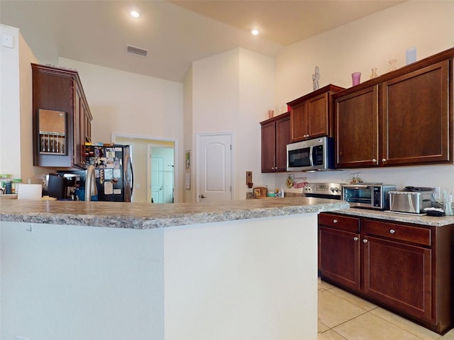 9677 SW 56th Cir, Ocala, FL 34476 - kitchen with stainless steel appliances, light tile patterned flooring, light countertops, a peninsula, and recessed lighting